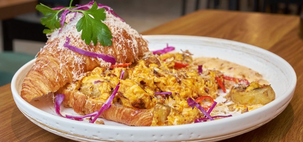 chilli scrambled egg with a croissant served on a white plate, from Ramsay Garden Cafe.