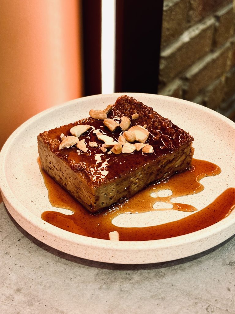 Slice of cake on white plate drizzled with treacle. Hop and Spice Ascot Vale.
