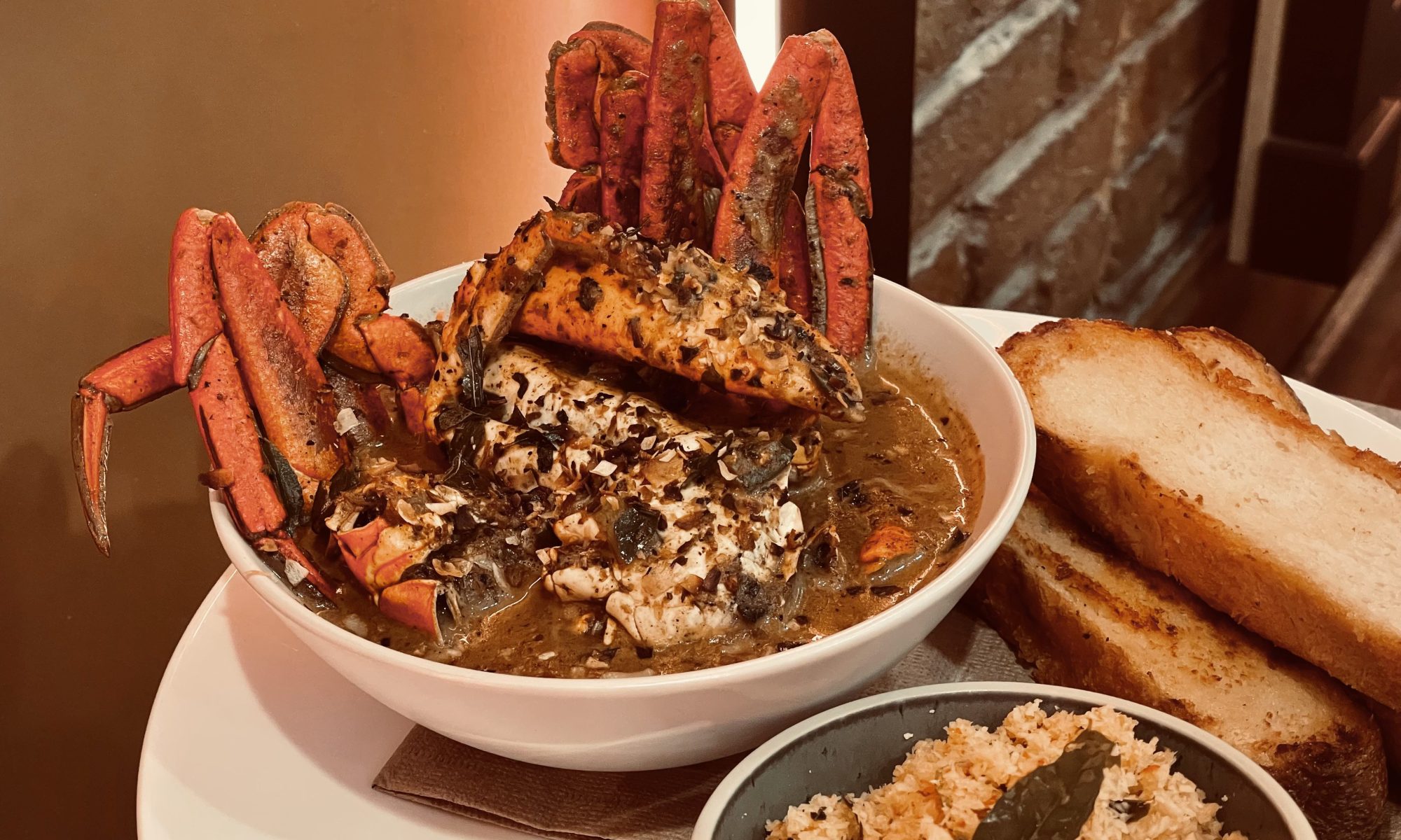 Mud crab curry on white plate with sambal and bread from Hop and Spice Ascot Avle.