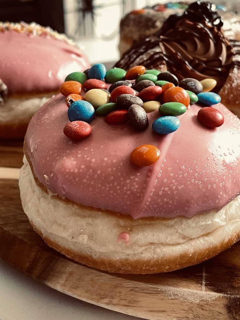 Close up of Daniel's Donut topped with pink icing and M n M's