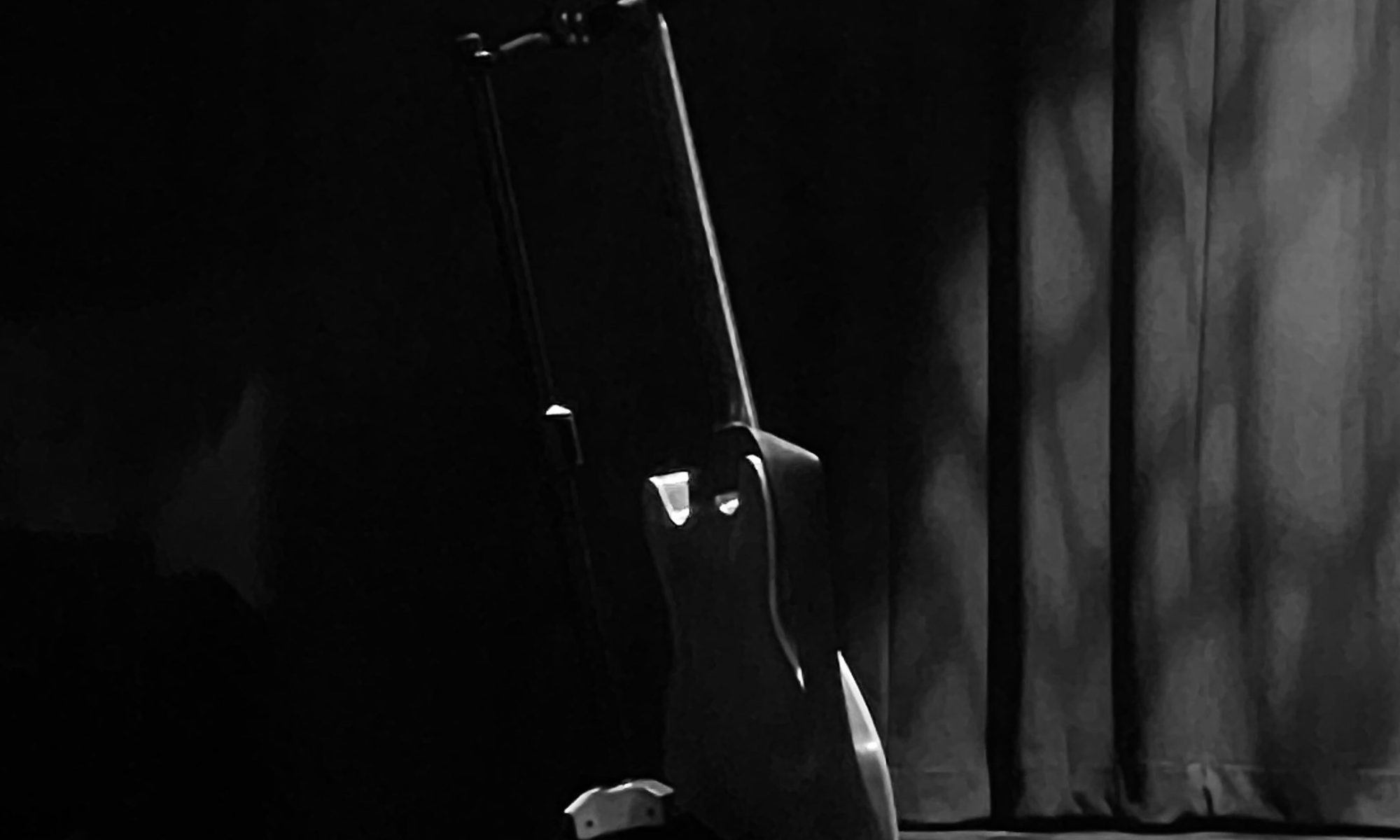 Black and white photo of guitar on guitar stand