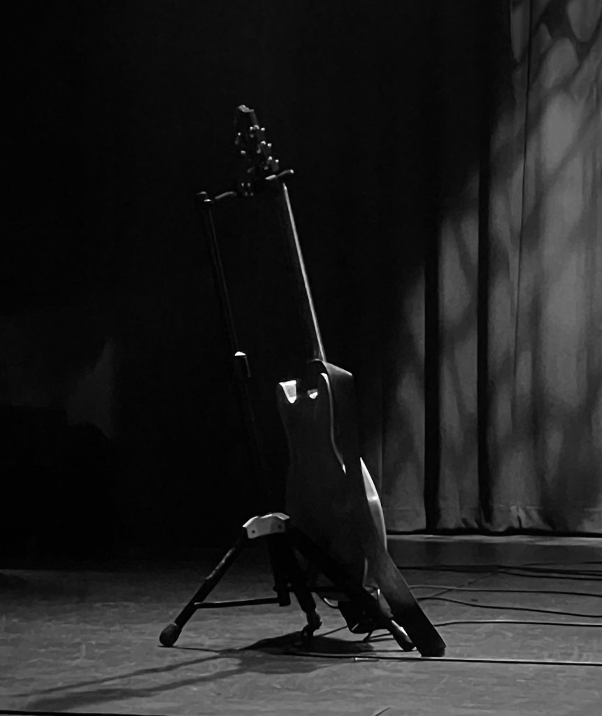 Black and white photo of guitar on guitar stand