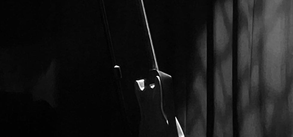 Black and white photo of guitar on guitar stand