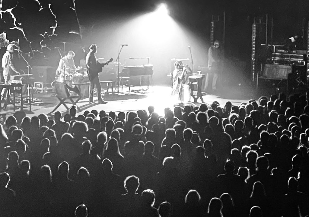 PJ Harvey and band on stage in Melbourne with crowd in foreground