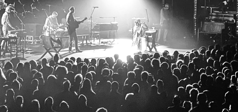 PJ Harvey and band on stage in Melbourne with crowd in foreground