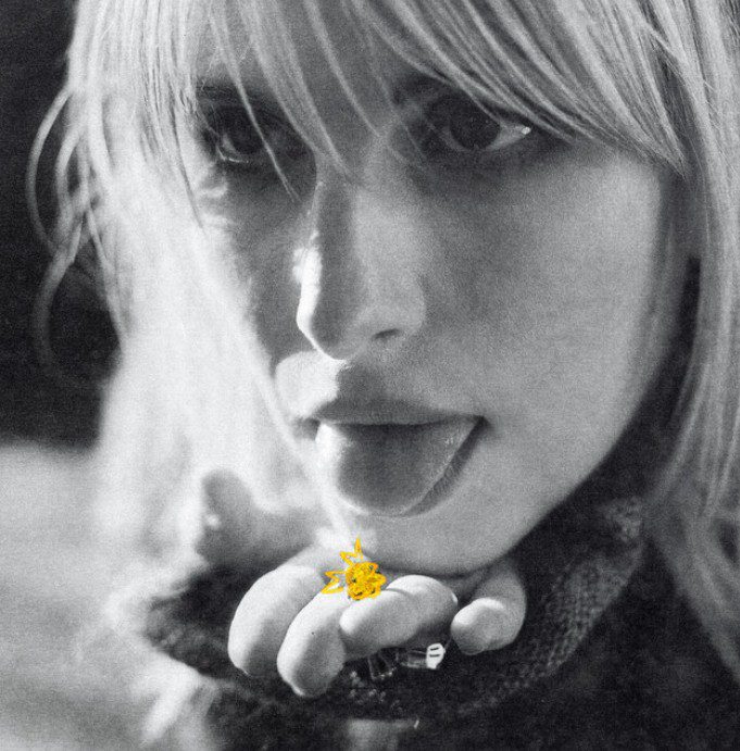 Hayley Williams in black and white with her tongue stuck out and her hand below her hand. There is a yellow scribble in the shape of a pill on her hand.