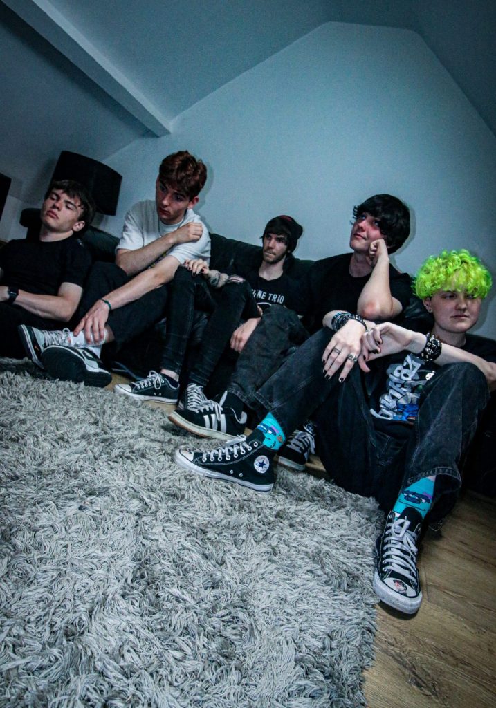 photo of the band OCHISIA sat down on a light coloured rug 