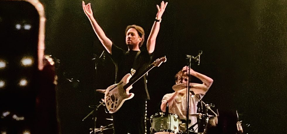 Matthew Murphy of the Wombats with his arms above his head at their gig at Festival Hall Melbourne September 2025
