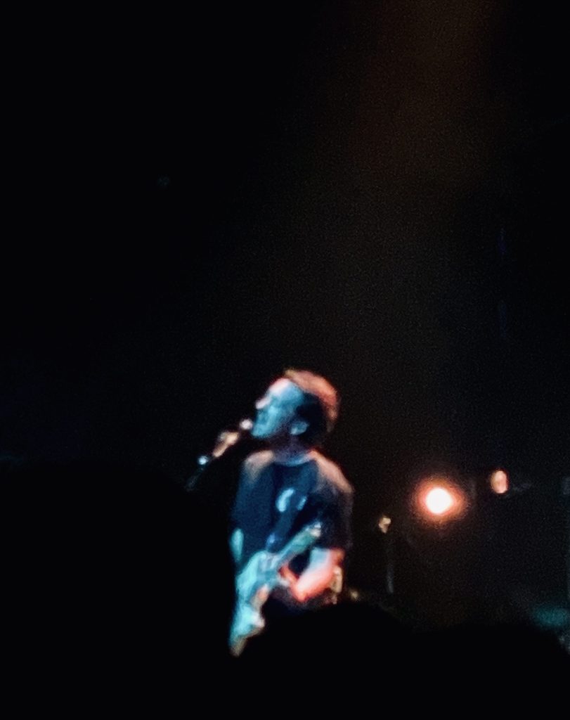 Matthew Murphy of the Wombats singing against a black background at their gig at Festival Hall in Melbourne