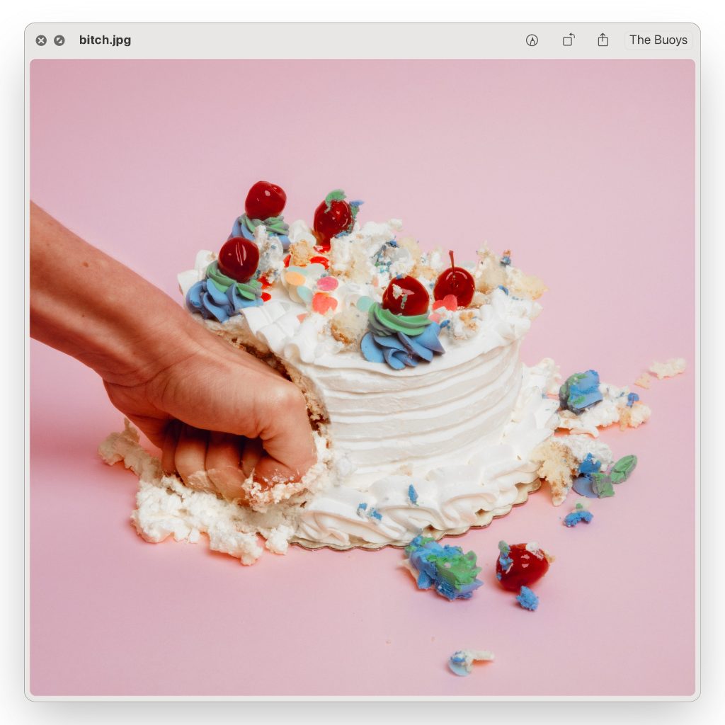 A hand punching a white cake on a pink background - The Buoys Bitch single cover