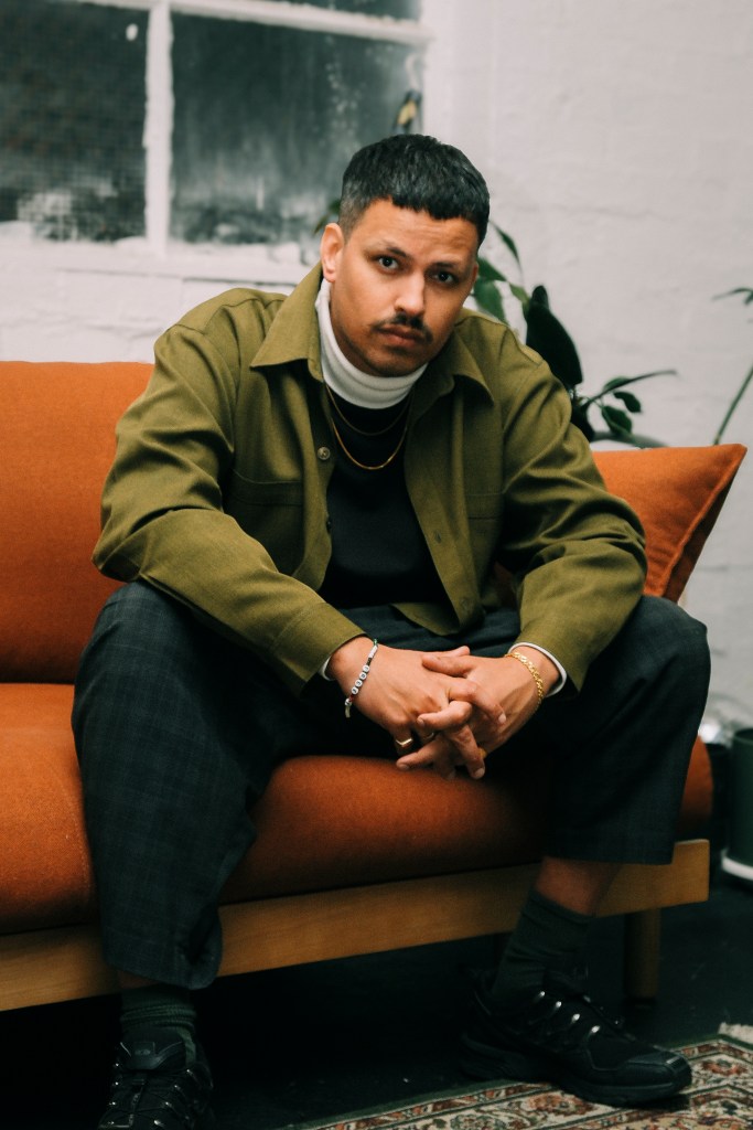 Musician MUDRAT sat on an orange sofa