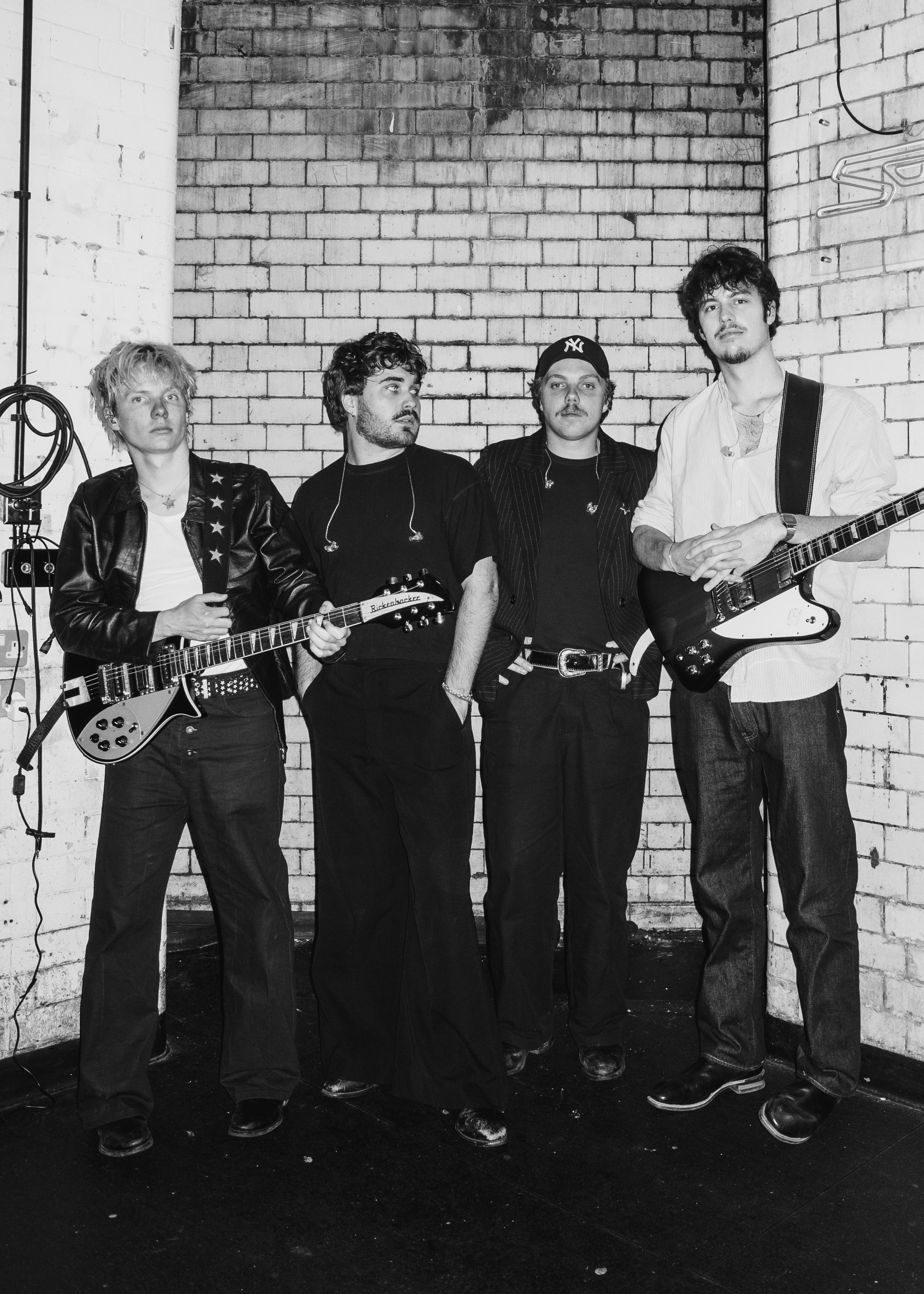 Black and white image of the band The Rions holding guitars.