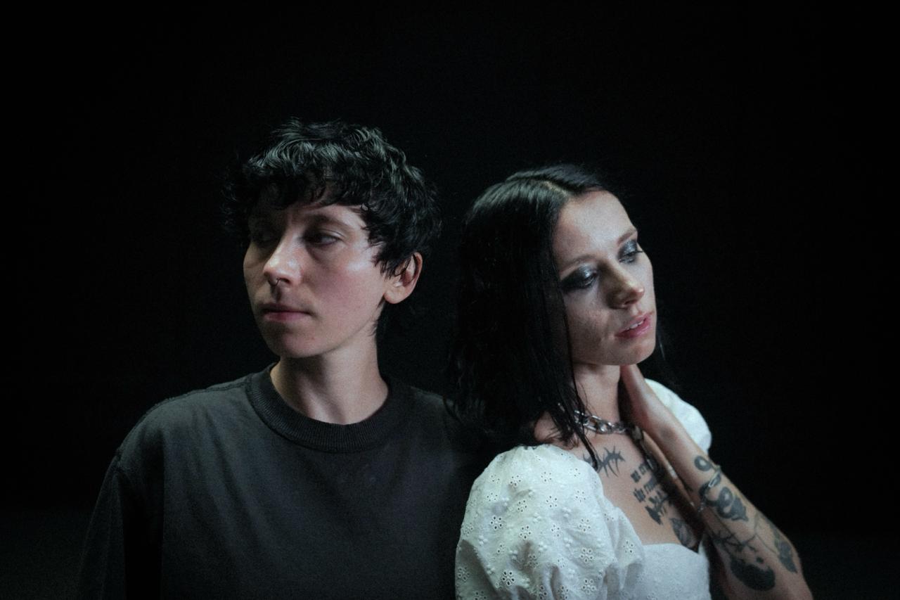 Image of Ontario band softcult, standing side by side. The image is dark and contrasting. 