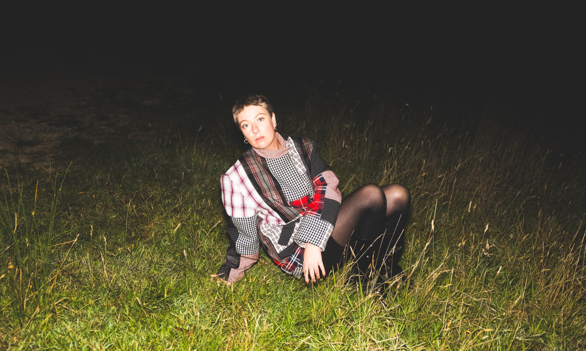Image of singer Jannah Beth sitting on grass.