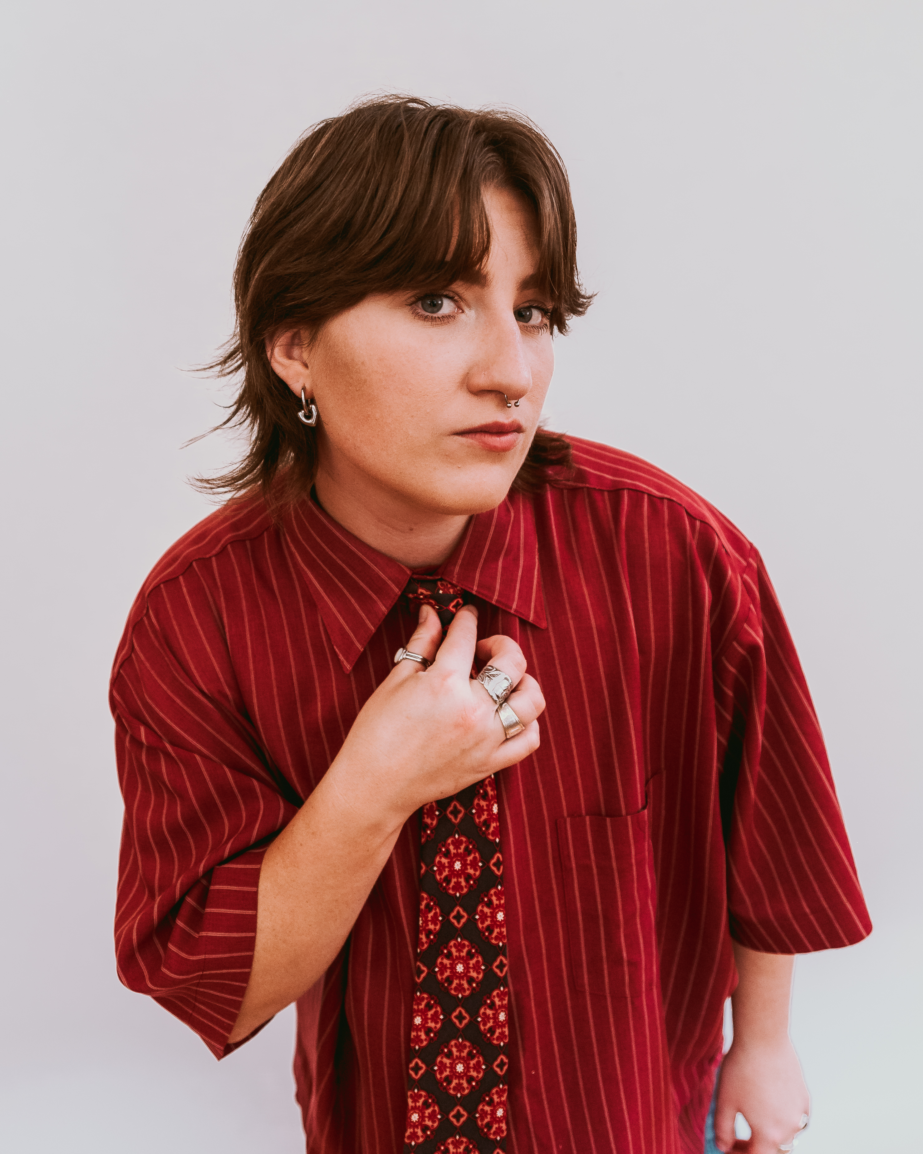 Image of Sam Sly wearing a red shirt and tie