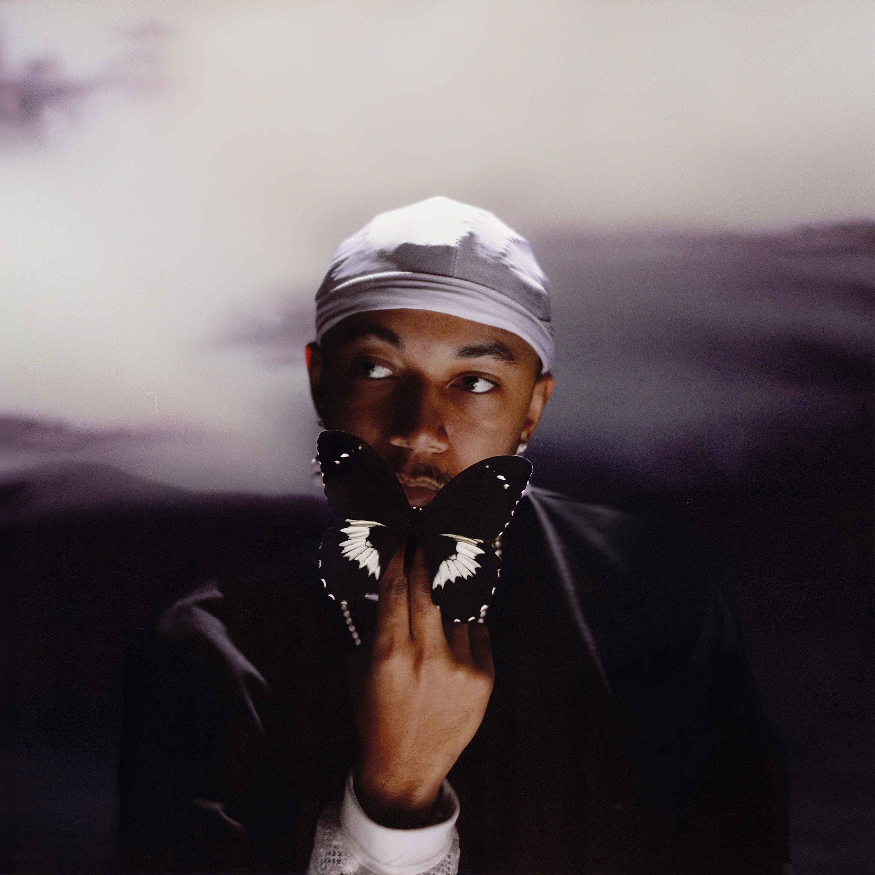 Wesley Jospeh holding a butterfly. Album cover for Forever Ends Someday