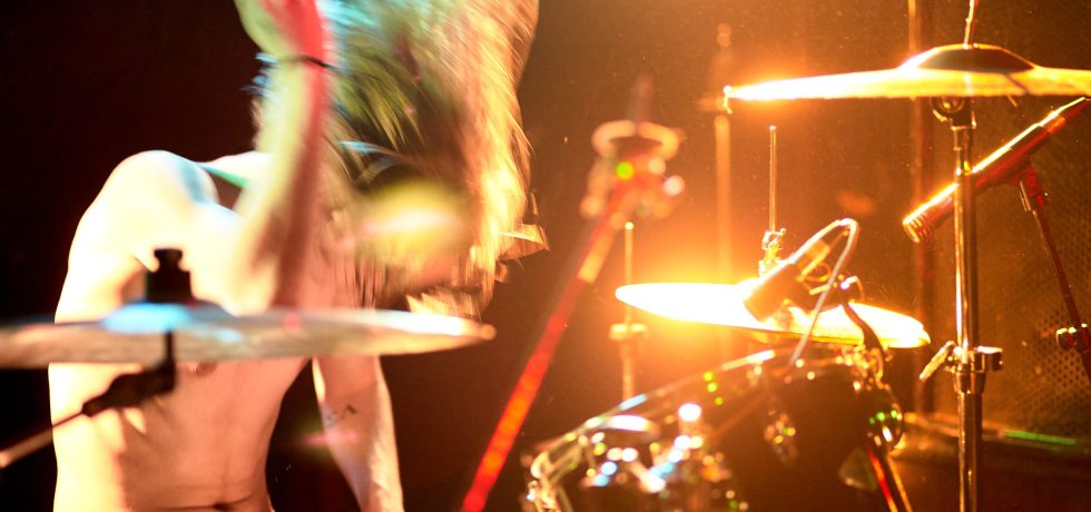 Drummer under warm orange lighting