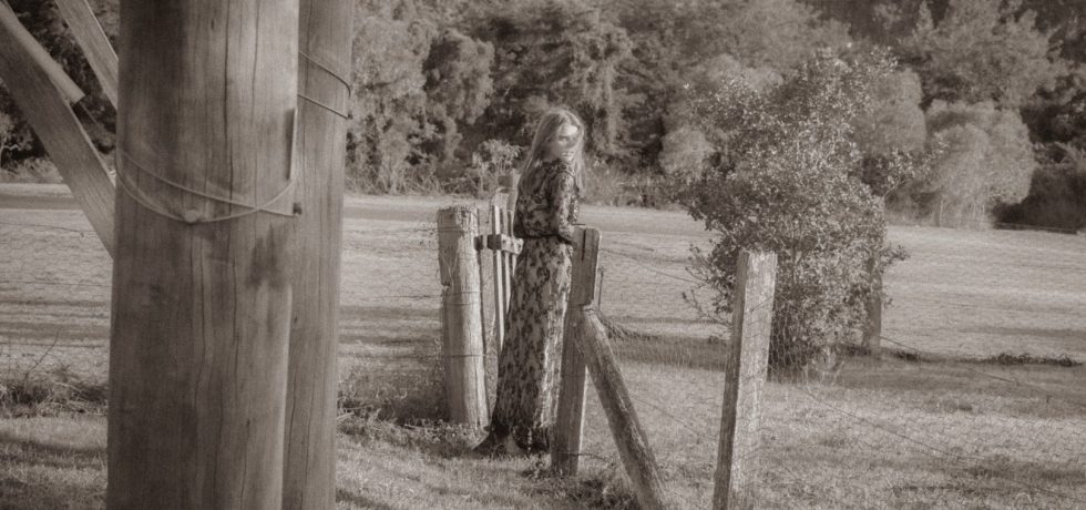 Black and white image of Jean Elliot looking out into a field