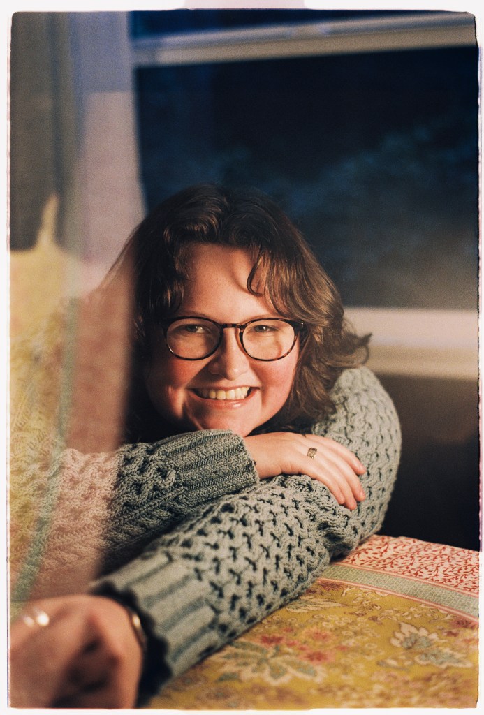Image of Aubory Bugg leaning on a table, smiling.