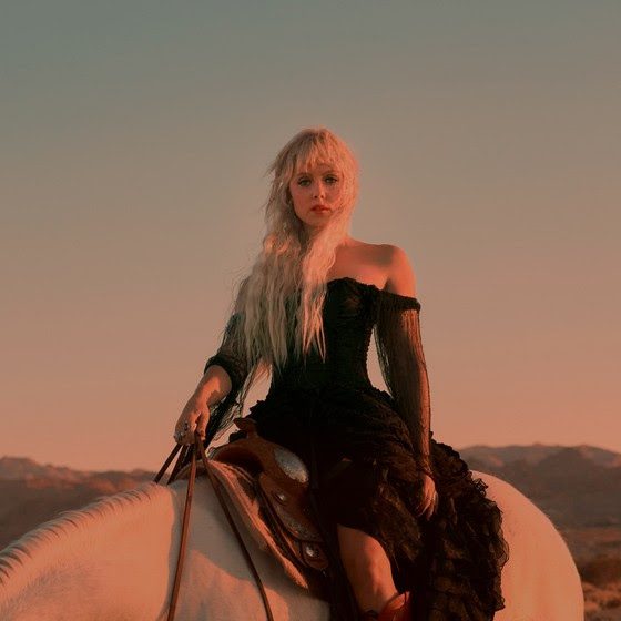Close up image of Iluka on horseback against an almost set sun.