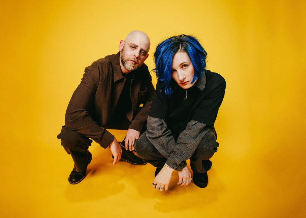Image of band Slothrust crouched against a yellow background