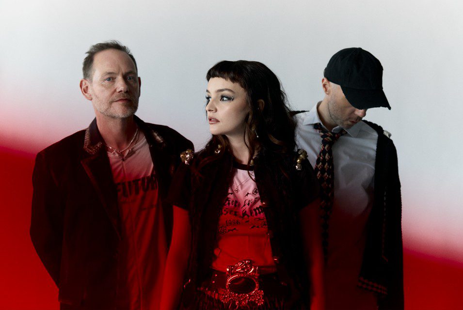 Image of band chvrches with a red band of light cutting across the bottom half of the image.