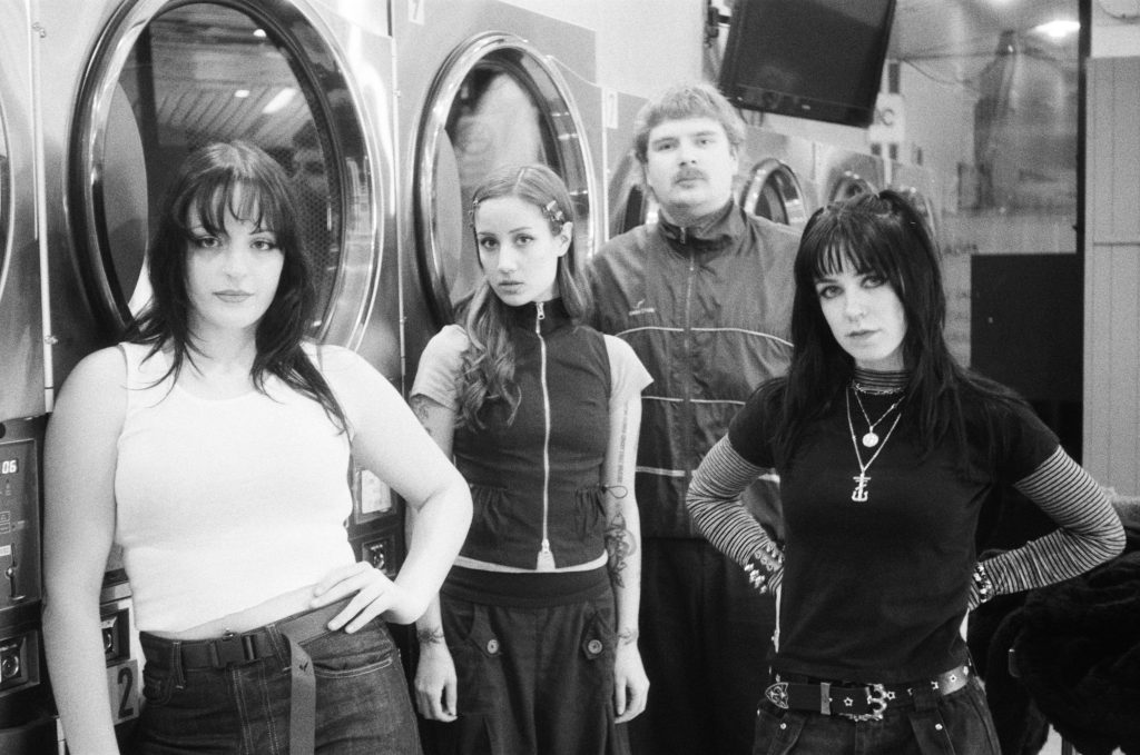Black and white image of Laura and The Hell Cutz taken at a laundromat
