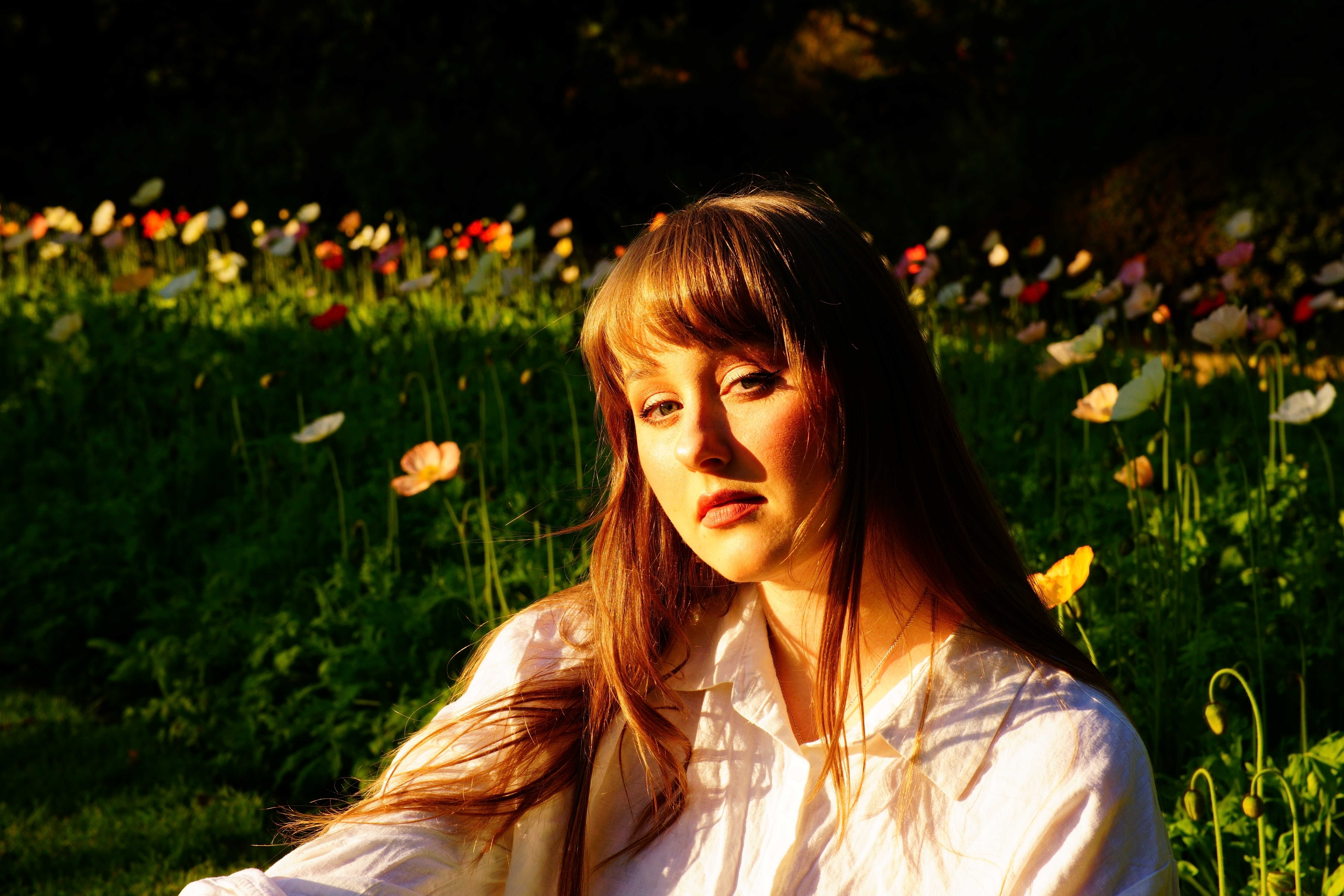 Image of Amanduh with a background of flowers in a park.