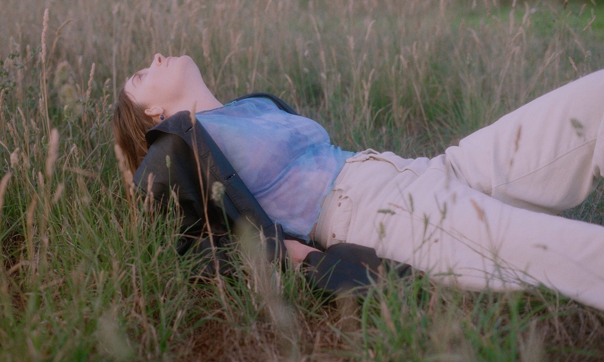 Image of Asha Jefferies lay in long grass.