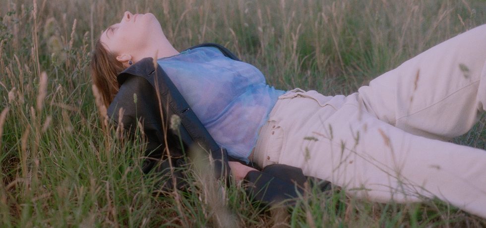 Image of Asha Jefferies lay in long grass.