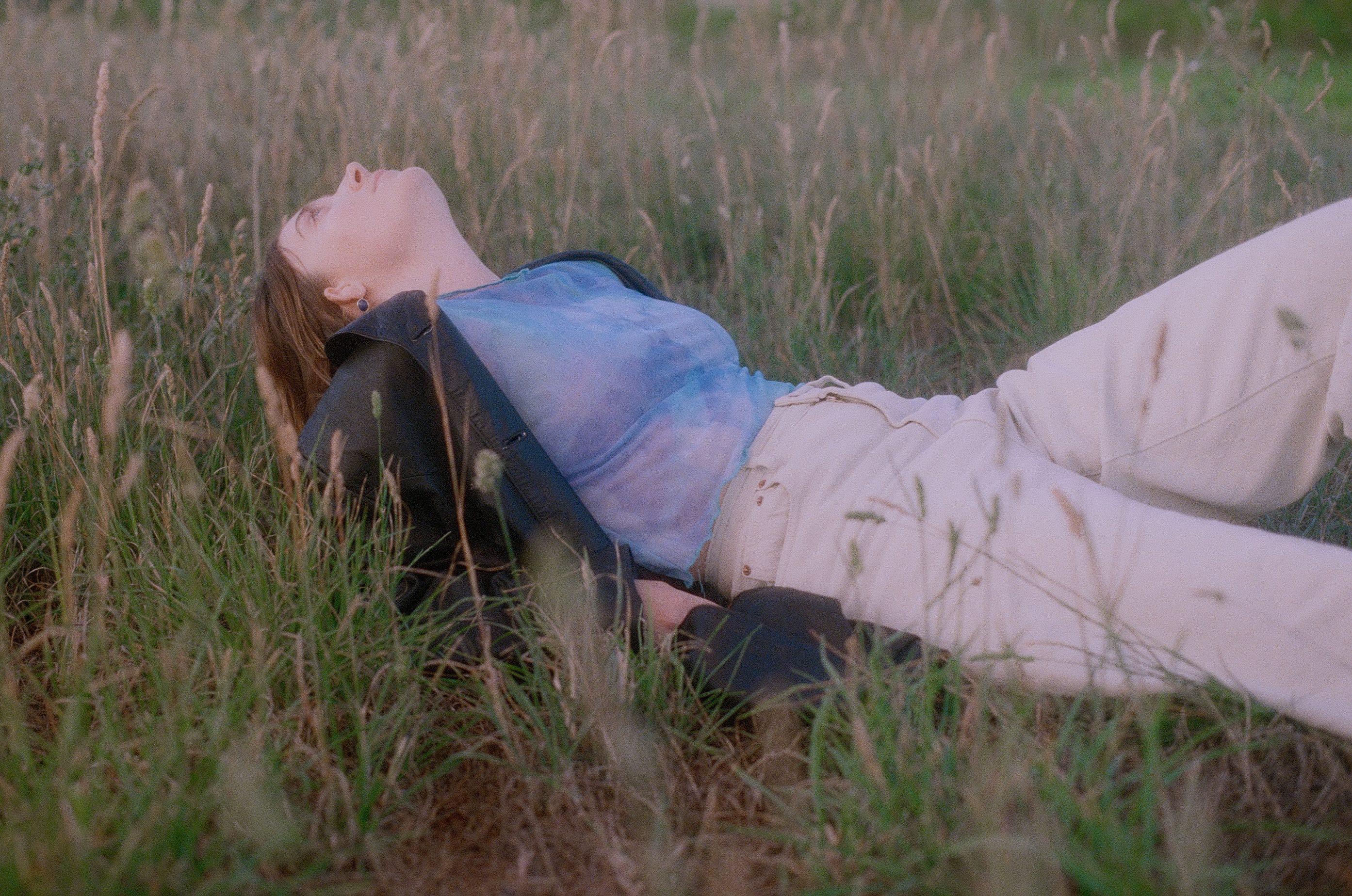 Image of Asha Jefferies lay in long grass.